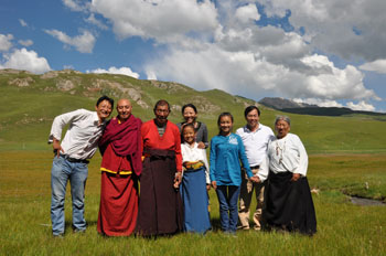 上照为董事长李海清与藏族养女代青尕毛一家在巴塘草原拍摄的“全家福”
